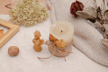 Fototapeta na wymiar Autumn vintage still life with fallen leaves, candles and a knitted blanket. Autumn atmosphere concept
