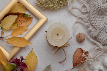 Autumn vintage still life top view with fallen leaves, dry rose, candles and knitted blanket. Autumn atmosphere concept