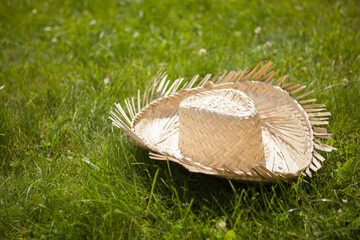 Farmer's yellow straw hat in the grass. Rural symbol.