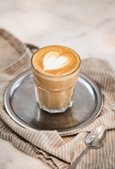 Glass of freshly brewed flat white coffee with heart shaped foam