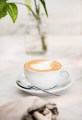 Cappuccino coffee drink in white cup and spoon