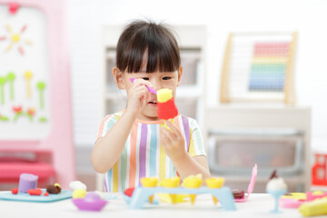 young girl making  ice lolly using dough tools  for homeschooling