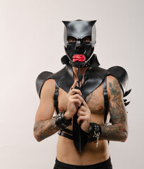 man in a bdsm mask of a demon-skull, dressed in leather with leather bracelets and belts