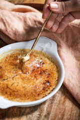 Hand of woman eating Crema Catalana Spanish dessert