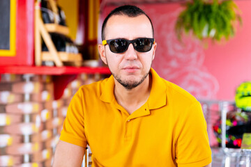 Portrait of a young latino man with sunglasses looking at camera.