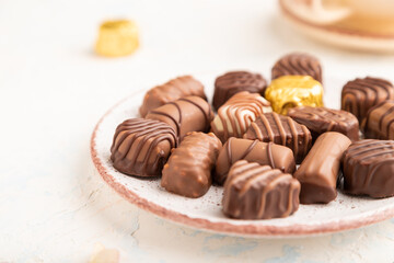 Chocolate candies with cup of coffee. side view, selective focus.
