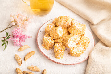 Traditional turkish delight (rahat lokum) with glass of green tea on a gray concrete background,...
