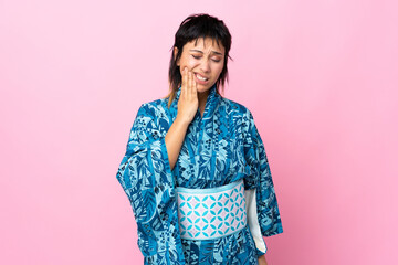 Young woman wearing kimono over isolated blue background with toothache