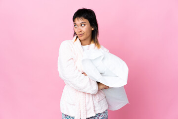 Young Uruguayan woman in pajamas over isolated pink background thinking an idea