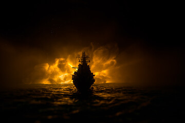 Silhouettes of a crowd standing at blurred military war ship on foggy background. Selective focus.