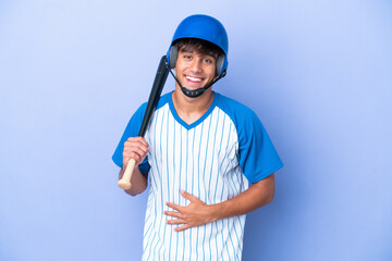 Baseball caucasian man player with helmet and bat isolated on blue background smiling a lot