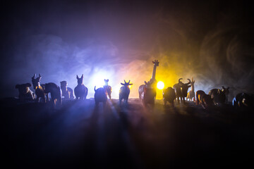 A group of animals are grouped together on a black background with glowing white rays. Animals range from an elephant, zebra, bear and rhino. Use it for a zoo or friends concept.