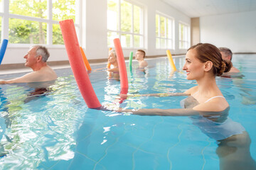Patients during remobilization in a health center doing aquarobics in the water of a pool