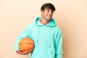 Handsome young basketball player man isolated on ocher background thinking an idea while looking up