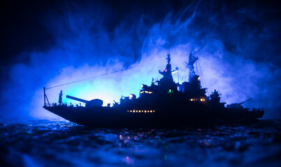 Silhouettes of a crowd standing at blurred military war ship on foggy background. Selective focus.