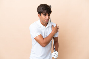 Young golfer player man isolated on ocher background suffering from pain in shoulder for having...