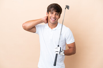 Young golfer player man isolated on ocher background laughing