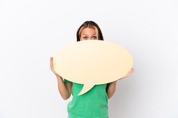 Teenager Russian girl isolated on blue background holding an empty speech bubble hiding behind it hiding behind it