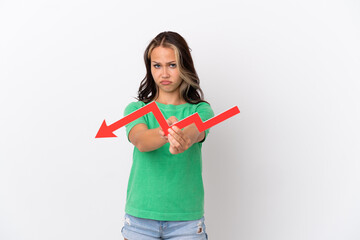 Teenager Russian girl isolated on blue background holding a downward arrow and with sad expression