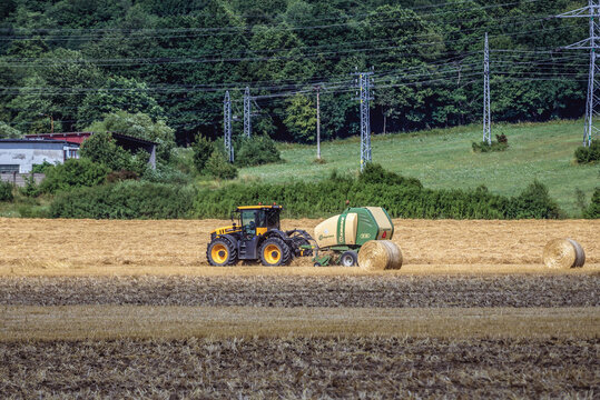 Kosice Region, Slovakia - July 20, 2019: Tractor with Krone Comprima round baler on a field