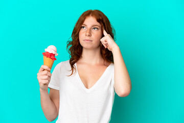 Teenager reddish woman with a cornet ice cream isolated on blue background having doubts and...