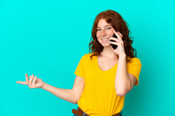 Teenager reddish woman using mobile phone isolated on blue background extending hands to the side for inviting to come