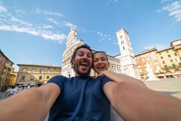 Travel tourists friends taking photo selfi with smartphone in Lucca, Tuscany. happy couple in love...