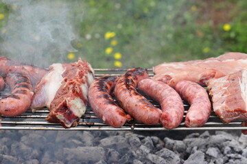 Assorted veal and pork meats cooking on the charcoal grill.