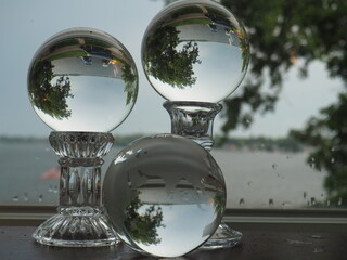 Three Glass Spheres Reflecting a Lake and Trees

