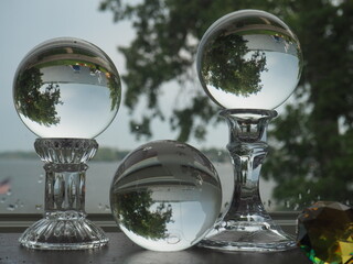 Three Glass Spheres Reflecting a Lake and Trees
