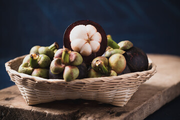 Mangosteen fruit in basket on wooden with blue color background, Tropical fruit