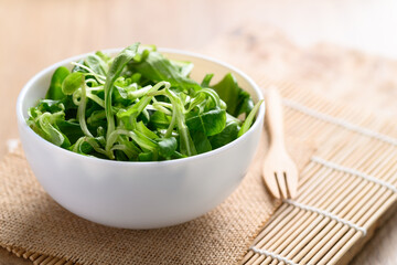 Fresh corn salad or lamb's lettuce in a bowl on wooden background, Fresh leaf vegetable mostly served as salad green