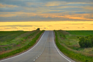 A beautiful sunset on the background of an asphalt road leading to the city of Blagoveshchensk in Russia.
