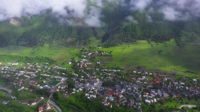 Aerial: Mestia highland town village in Caucasus Mountains valley, Georgia