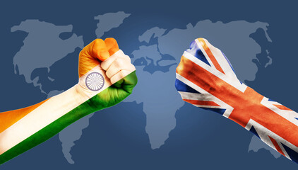 United Kingdom vs INDIA concept, hands painted India flag and United Kingdom or UK flag on hands punch to each others on world map background
