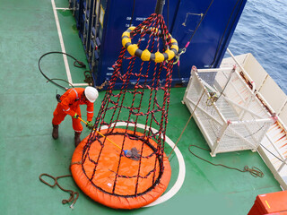 Workers is cleaning the  personal basket for lifting the worker by the crane from supply boat to...