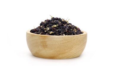 Black wolfberry in wooden bowl isolated on white background. Commonly known as black fruit wolfberry, goji nero, siyah goji. Used in traditional Chinese medicine, herbal tea
