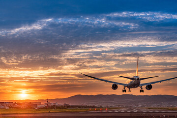 Fototapeta na wymiar 美しい空を背景に着陸する飛行機のシルエット