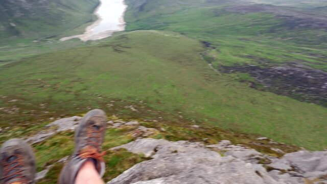 A Point Of View Shot Of Looking Over The Edge Of A Cliff Whilst Dangling Feet Over The Edge. 