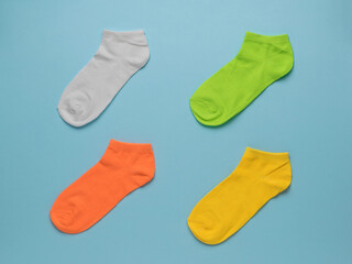 Four colorful beautiful socks on a blue background. Flat lay.
