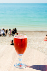 Verre de monaco, posé sur une table en terrasse, devant la mer