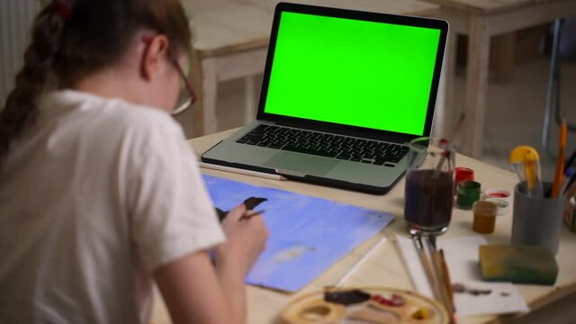 Art school online lesson girl draws picture near laptop Spbas