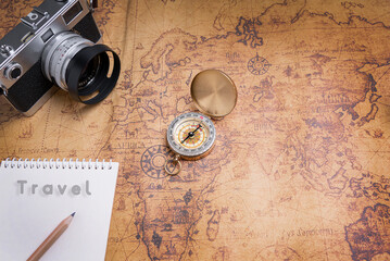 Fototapeta na wymiar Vintage Compass and camera on map for travel planning