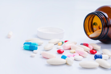 Pills spilling out of bottle on isolated white background