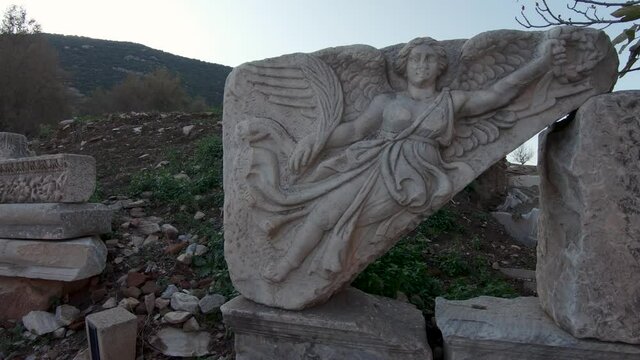 Panning shot of relief of winged Nike, the Greek goddess of Victory, on Kuretes Street, Ephesus.