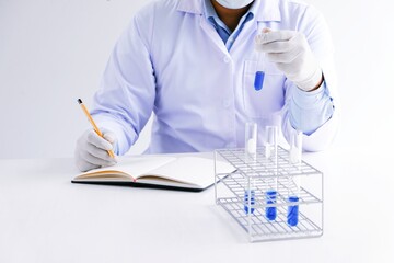 Science innovative Male medical or scientific laboratory researcher performs tests with blue liquid in laboratory. equipment science experiments technology Coronavirus Covid-19 vaccine research