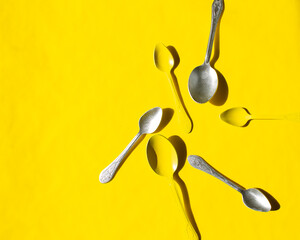 yellow background. gray and yellow spoons.