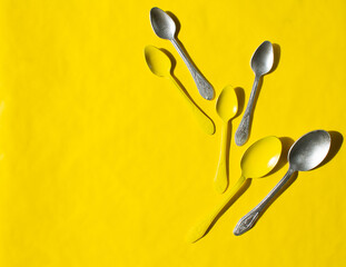 yellow background. gray and yellow spoons.