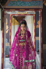 Close up portrait charming Asian woman wearing a traditional saree looking at down hile traveling in Wat Pra Kaew in Thailand