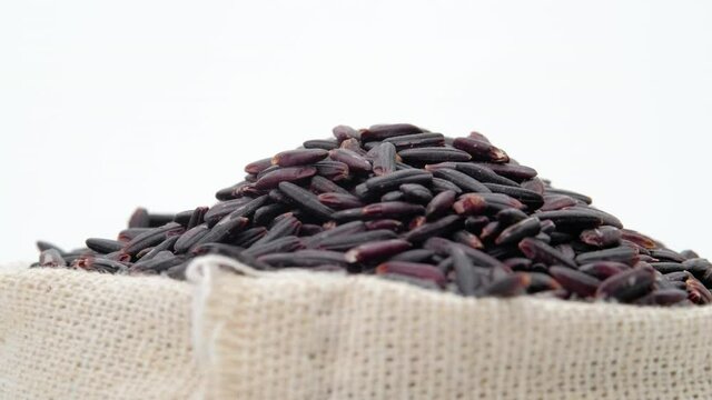 Macro shot of Black rice berry in bag on white background, Rotation shot, Close up.